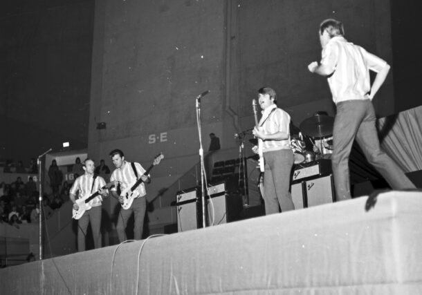 Les Beach Boys en concert à l’aréna Maurice-Richard. 19 février 1965. VM94-S32-013. Archives de la Ville de Montréal. De gauche à droite : Al Jardine, Glen Campbell (qui remplace Brian Wilson), Carl Wilson, Dennis Wilson (derrière la batterie) et Mike Love.